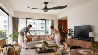 Matte black smart ceiling fan in a modern Singapore living room with a family arranging cushions