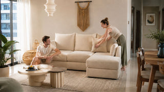 Cream chaise sofa in a bright Singapore living room with a couple arranging cushions for everyday comfort