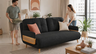MegaFurniture charcoal sofa with cane side panels in a modern Singapore condo living room as a couple arranges cushions.