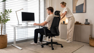 White adjustable work desk with black ergonomic chair and task lamp in a bright Singapore home office for work-from-home professionals