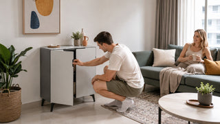 Modern two-door cabinet with tempered glass top in a bright Singapore living room with a couple arranging the storage space.
