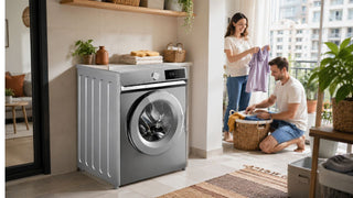 Silver front load washing machine in a bright Singapore laundry nook with a couple sorting clothes in a practical home setting
