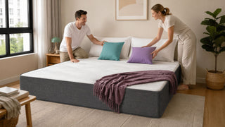 White vacuum mattress in a modern Singapore bedroom with a couple arranging cushions for a practical guest-ready setup