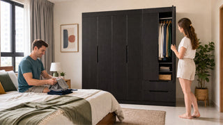 Dark wood wardrobe system in a modern Singapore bedroom with open storage and a couple organising clothes