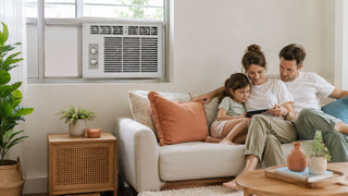 Family relaxing in a modern Singapore living room with a compact window aircon installed above the seating area.