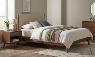 Mid-century modern bedroom with walnut bed frame, tapered side table, neutral bedding, and wooden dresser in a warm Singapore home.