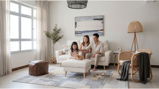 Family relaxing on a cream sofa in a bright minimalist Singapore living room with ottoman and rattan accents