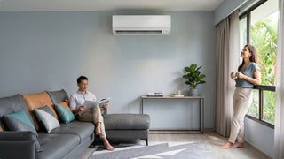 Wall-mounted Mitsubishi air conditioner in a bright Singapore living room with sectional sofa and balcony windows