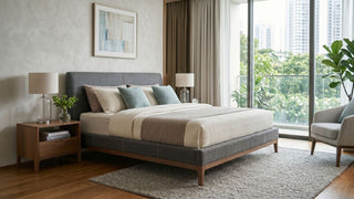 Modern Singapore condo bedroom with a grey fabric bed frame, wood bedside table, soft neutral bedding and large windows overlooking greenery.