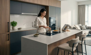 Woman cooking on an induction hob in a modern open-concept Singapore kitchen with a built-in cooker hood