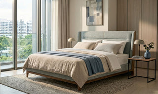 Modern queen bed frame in a bright Singapore condo bedroom with neutral bedding, bedside tables, and large windows.