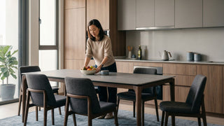 Modern Singapore kitchen with built-in hob, concealed hood, wood cabinetry and dining table in a compact open-plan home.