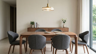 Wooden dining table with grey upholstered chairs in a bright Singapore dining area with sideboard and pendant light.