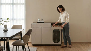 Woman organising cutlery in a narrow sideboard cabinet beside a dining table