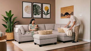 Parents with newborn on a light grey sectional sofa in a cosy Singapore living room with storage baskets