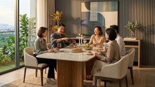 Family hosting dinner around a Nordic dining table in a warm modern Singapore condo