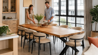 Oak wood dining table in a modern Singapore condo dining area with a couple preparing the table for guests.