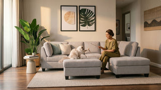 Woman playing with a cat on a light grey ottoman sofa with chaise in a modern living room