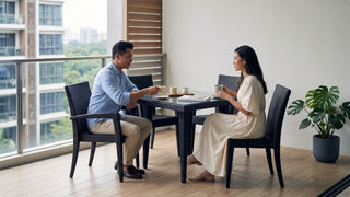 Couple having coffee at a black outdoor balcony table with matching chairs in a Singapore apartment balcony