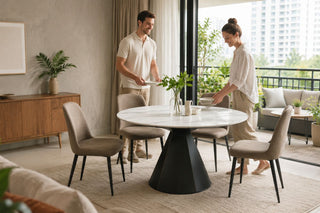 Round marble dining table set beside a balcony in a modern Singapore condo, prepared for casual outdoor dining.