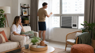 Panasonic window air conditioner cooling a bright modern Singapore living room with a relaxed couple.