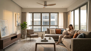Singapore condo living room with a wood-blade Panasonic ceiling fan, sectional sofa, coffee table and warm daylight.