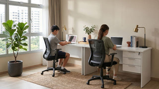 Parent and child working at separate white desks in an HDB study room with black mesh chairs, drawers, and natural light