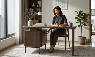 Woman using a wooden pedestal cabinet beside a home office desk in a bright Singapore apartment.