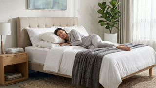 Woman sleeping on a pillow booster in a cosy bedroom with neutral bedding