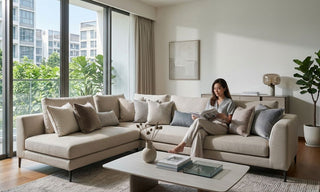 Beige sectional sofa with layered pillows and cushions in a bright Singapore condo living room
