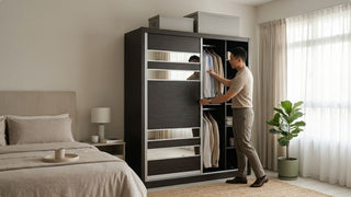 Man organising clothes in a Poliform-style sliding wardrobe in a modern Singapore bedroom