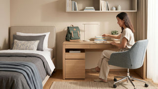 Parent arranging school books on a study desk beside a bed in a Singapore child’s bedroom