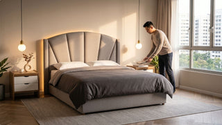 Man styling bedside table beside a queen bed frame in a bright modern Singapore bedroom