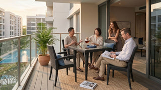 Friends gathering around a rattan balcony table set on a modern Singapore condo balcony