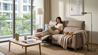 Woman reading on a beige recliner sofa in a bright Singapore condo living room