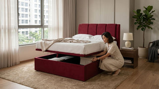 Woman placing storage box inside a red upholstered Forty Two storage bed in an HDB bedroom