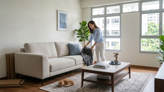 Woman arranging a sofa in a resale HDB living room after furniture delivery