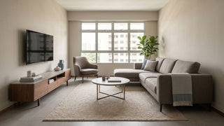 Resale HDB living room in Singapore with L-shaped sofa, wall-mounted TV, wooden TV console, coffee table, rug, and armchair.