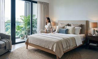 Resort-style bedroom with natural textures, warm lighting, indoor plants, and neutral bedding in a Singapore condo.