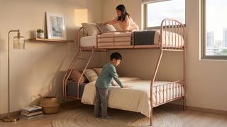 Rose gold kids bunk bed with ladder, full guardrails, soft bedding, and warm natural light in a Singapore-style bedroom