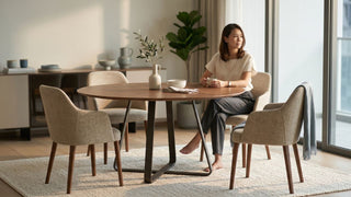 Round wooden dining table with four-leg base and upholstered chairs in a modern Singapore condo dining space