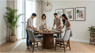 Family setting a round wooden dining table with upholstered chairs in a bright Singapore home