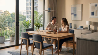 Couple sitting at a Scandinavian wooden dining table in a bright Singapore condo dining area
