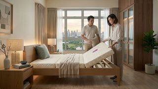 Couple placing a Seahorse foldable mattress on a slatted bed frame in a bright Singapore bedroom