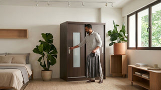 Man opening a dark wood sliding wardrobe in a modern bedroom with plants, wooden furniture and natural light