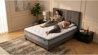 Somnuz mattress in a warm modern bedroom with grey bed frame, bedside tables and couple relaxing at home