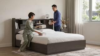 Couple organising a dark wood storage headboard bed with shelves in a bright Singapore bedroom
