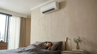Woman sleeping beneath a wall-mounted System 2 aircon in a compact Singapore condo bedroom
