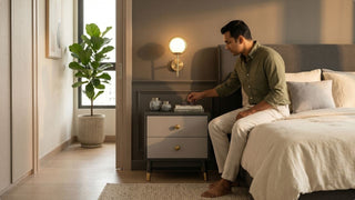 Grey two-drawer bedside cabinet styled with books and decor in a warm modern Singapore bedroom