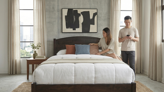 Walnut bed frame in a Singapore bedroom with warm wood tones and modern styling